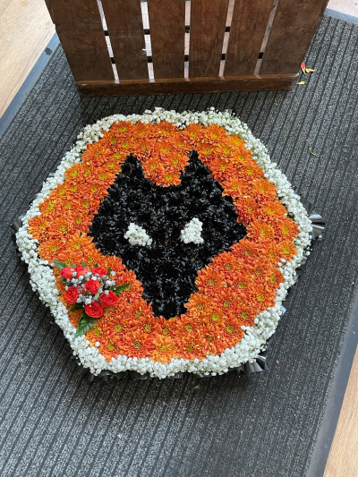 Wolves Badge Tribute - A striking Wolves crest funeral cushion in the club’s iconic orange and black colours, handcrafted by Pursehouse Florist in Cannock for a devoted supporter.