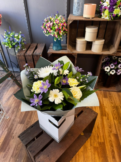 Lavender Dreams - A beautiful combination of soft lilac, delicate cream and fresh greenery, thoughtfully arranged to create an elegant and charming display. Presented in a stylish gift bag, this lovely arrangement is perfect for celebrating a special occasion or sending a little happiness to someone you love.