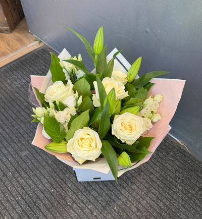 Lily Rose - A timeless arrangement featuring beautiful ivory and soft cream tones, complemented by lush greenery. Expertly arranged and presented in a stylish gift bag, this sophisticated design is perfect for anniversaries, birthdays, expressing sympathy or simply sending a thoughtful gift.