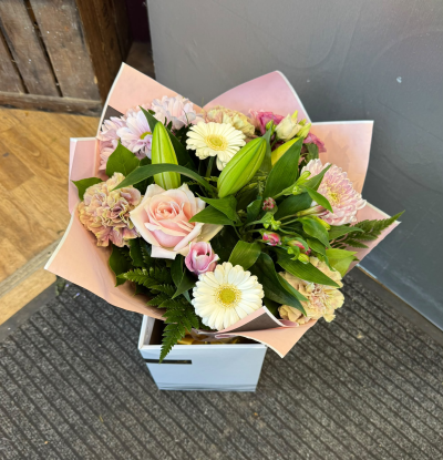 Blushing Beauty - A delightful arrangement featuring a romantic blend of soft pink, delicate blush and creamy white tones. Beautifully complemented by fresh greenery and presented in a stylish gift bag, this charming design is perfect for birthdays, anniversaries, new arrivals or simply showing someone how much you care.