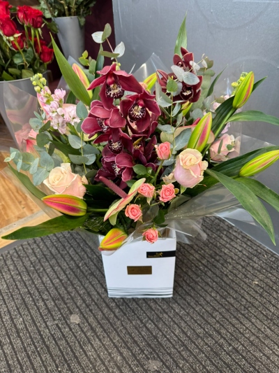 Enchanted Elegance - A luxurious arrangement combining rich burgundy, delicate pink and soft pastel tones with beautiful greenery. Expertly arranged and presented in a stylish gift bag, this sophisticated design is perfect for celebrating a special anniversary, marking a milestone or treating someone to something truly memorable.