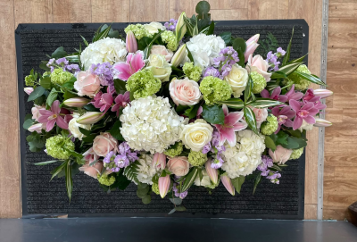 Whispers of Love - A luxurious, full-length funeral spray featuring a delicate combination of soft blush pink, ivory, lilac and fresh green tones. Beautifully arranged with an abundance of natural greenery, this elegant tribute offers a graceful and heartfelt way to honour the memory of someone dearly loved.